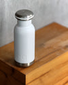 small white water bottle on wooden block