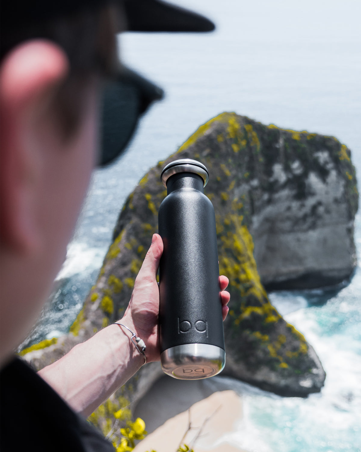Spring break holding black water bottle with sunglasses