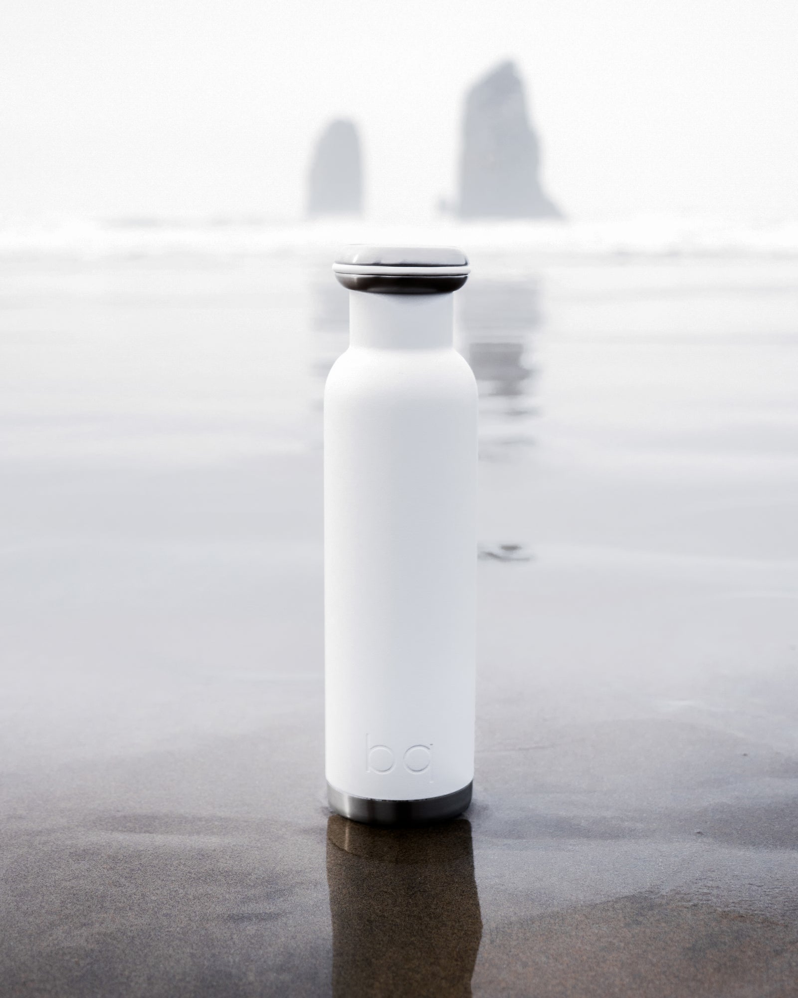 white water bottle on sandy beach