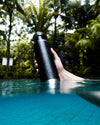 Drinking with black water bottle in summer pool