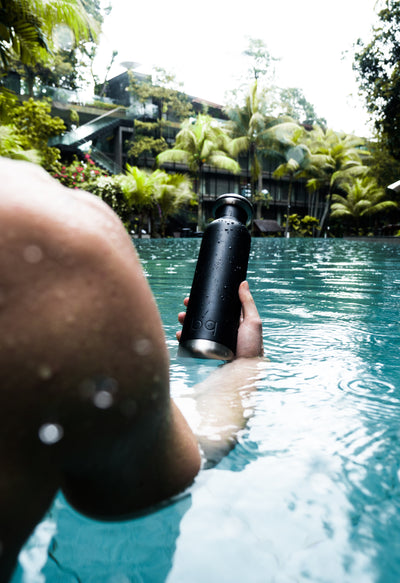 vacation in the pool with black bq bottle